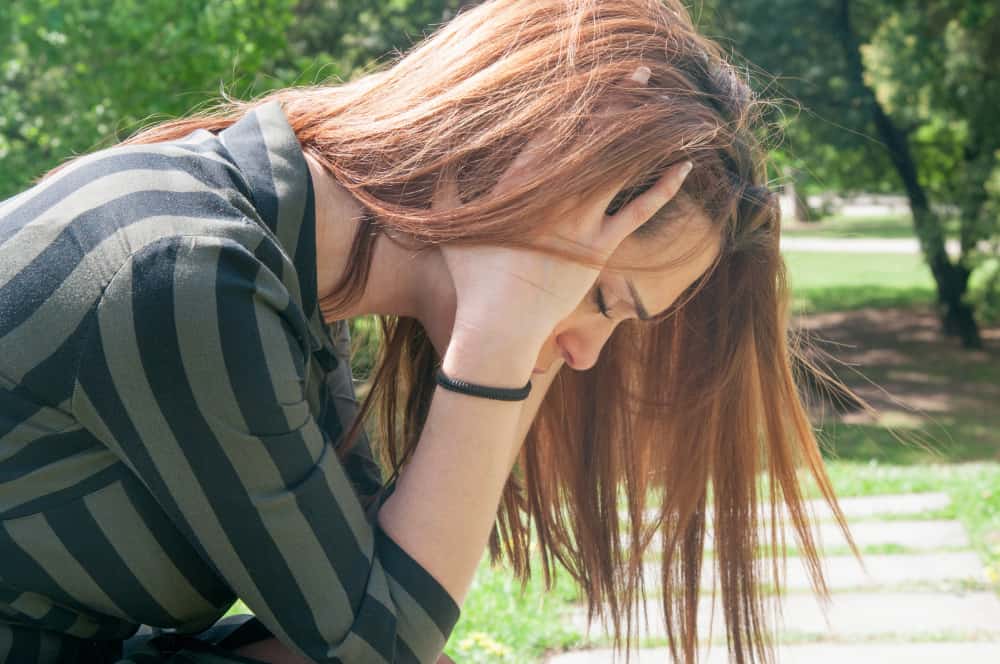 adolescente se mettant la tête dans ses mains